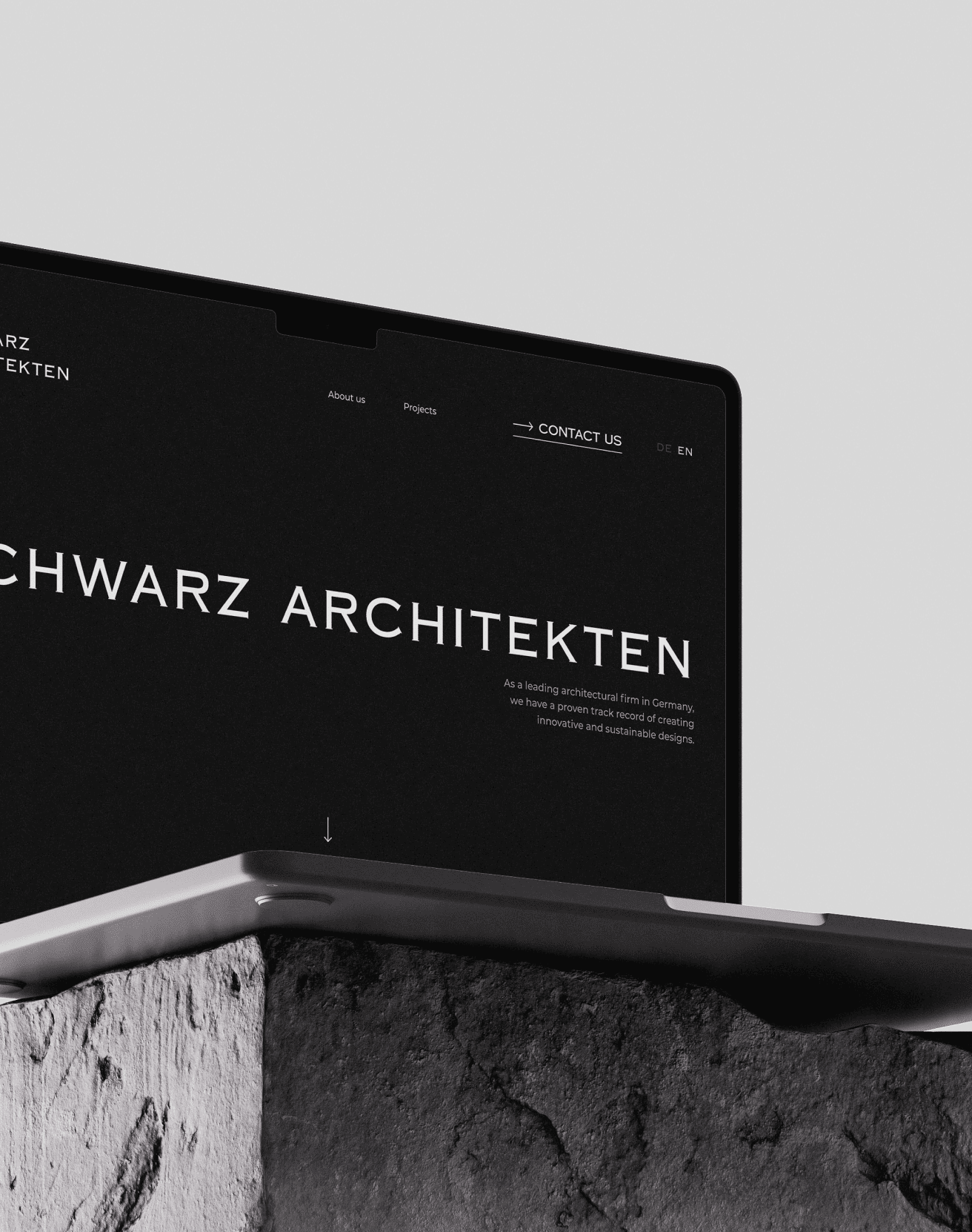 Laptop mit Webseite von Schwarz Architekten in Schwarzweiß auf steinernem Sockel